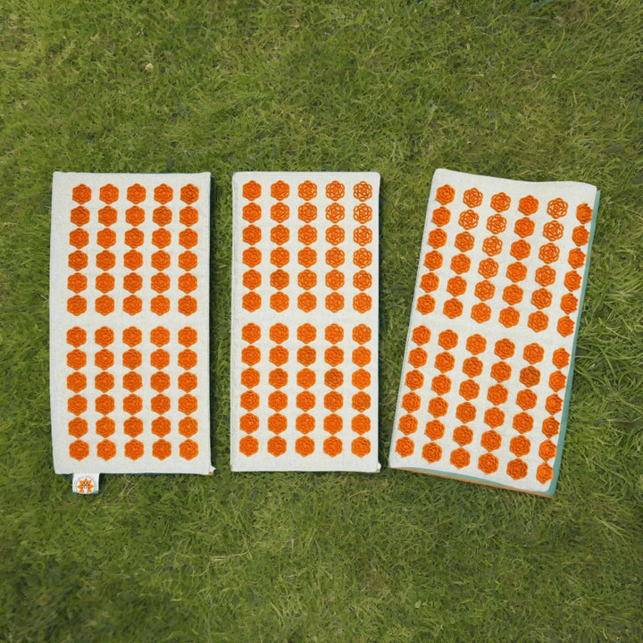 Acupressure mat on grass in a park.