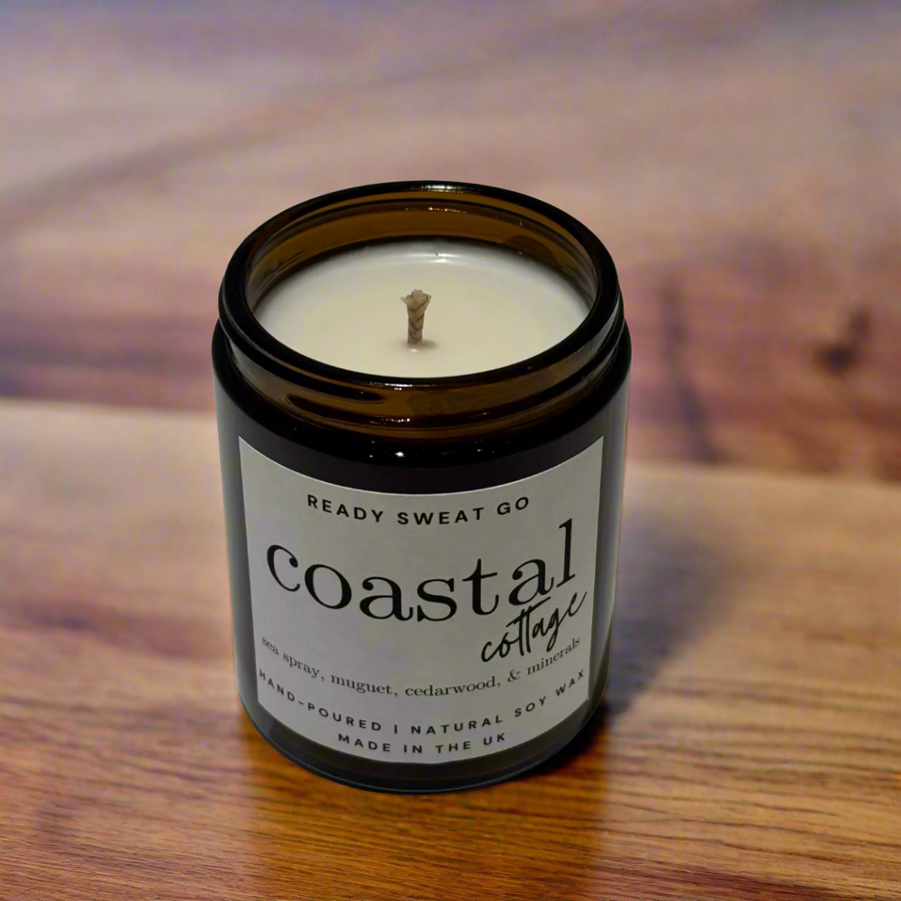 Candle sits on a polished sandalwood surface with red tones